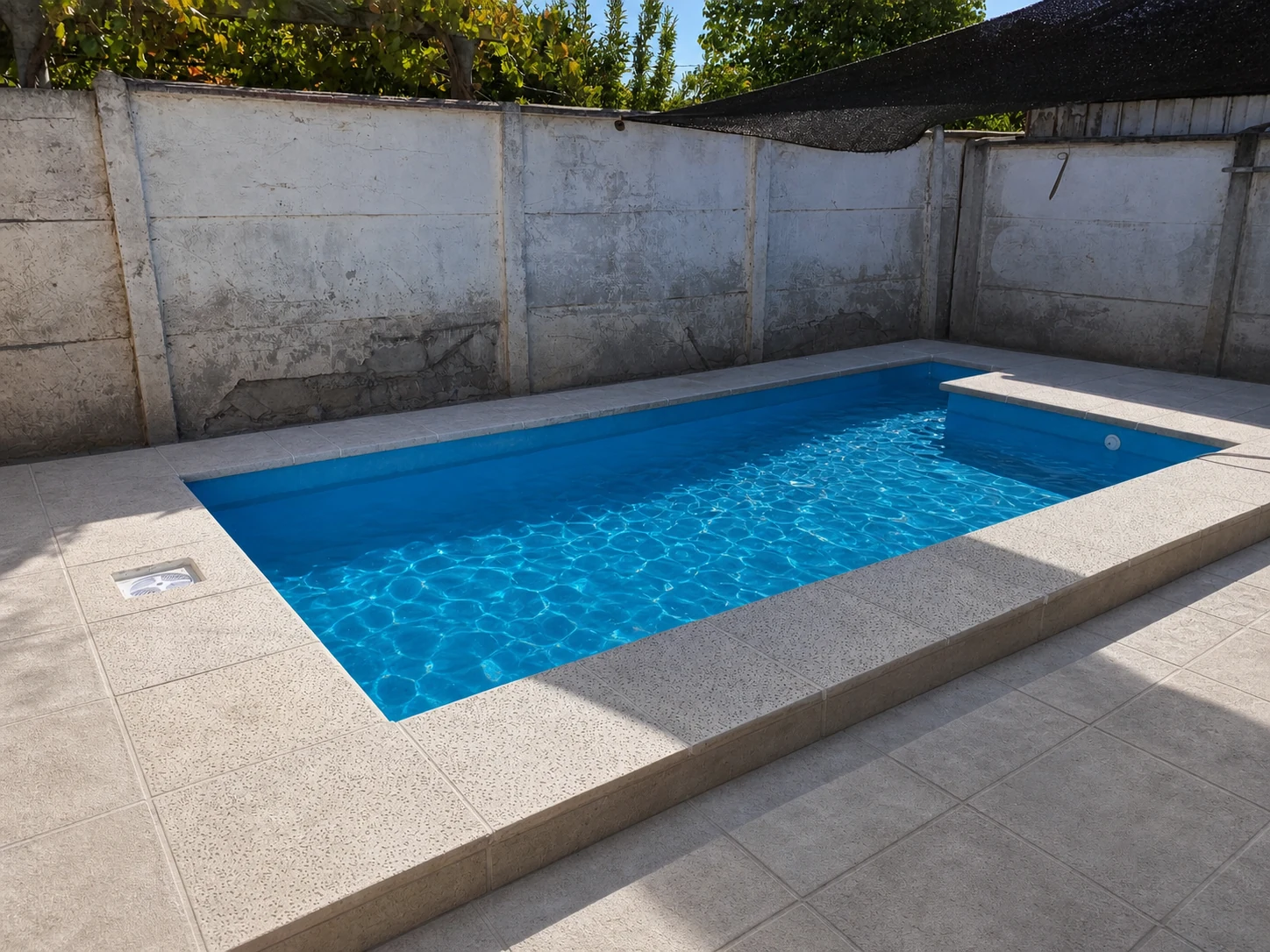 Piscina compacta terminada en patio residencial